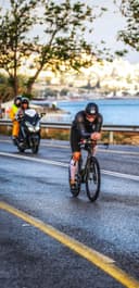 Christian Plesca on the time trial bike at first light, followed by a race motorbike.