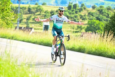 Christian Plesca riding the road bike with both arms spread wide.