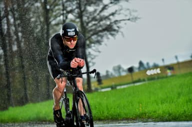 Christian Plesca riding the time trial bike through heavy rain.