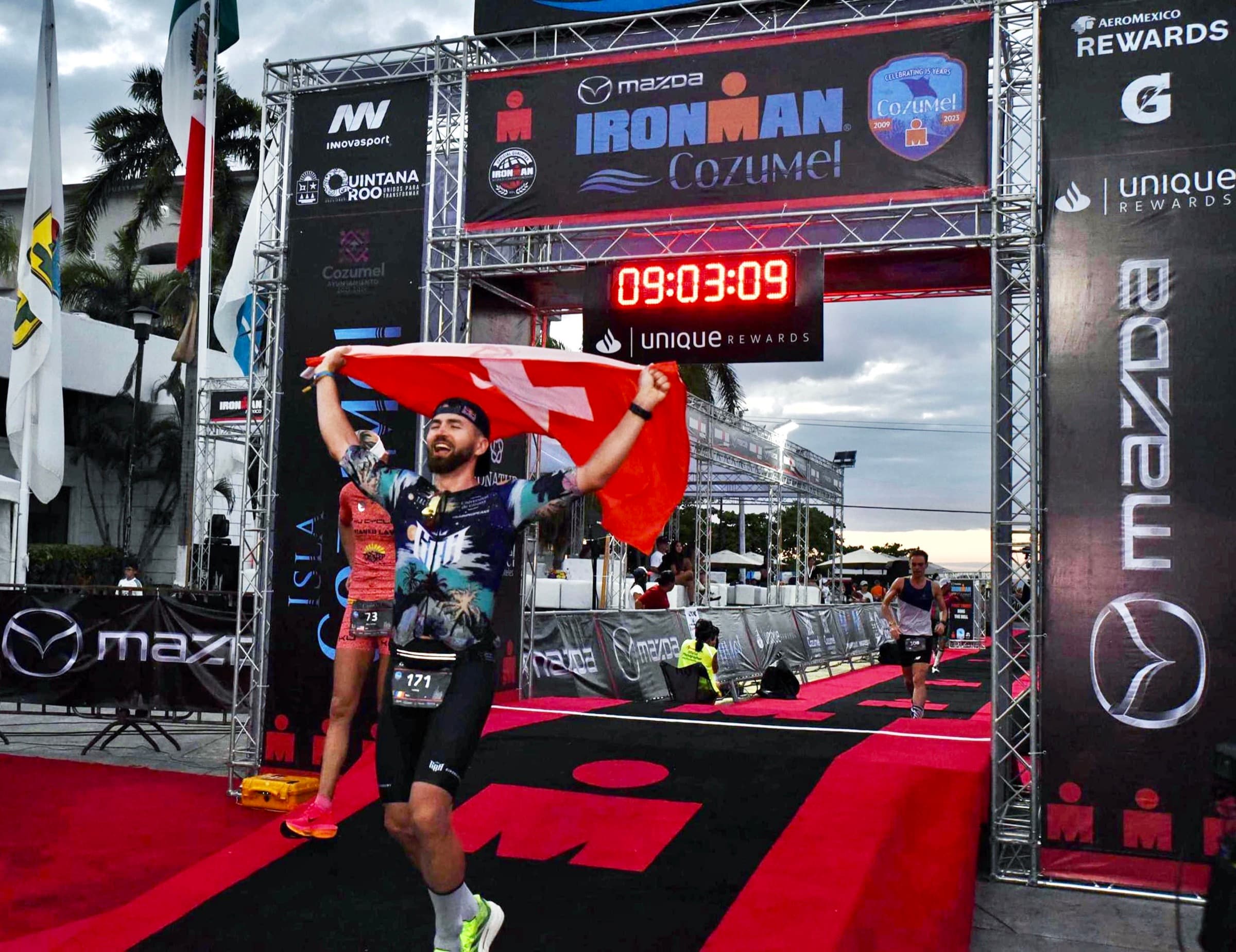 Christian Plesca finishing IRONMAN Cozumel 2023 with the Swiss flag.